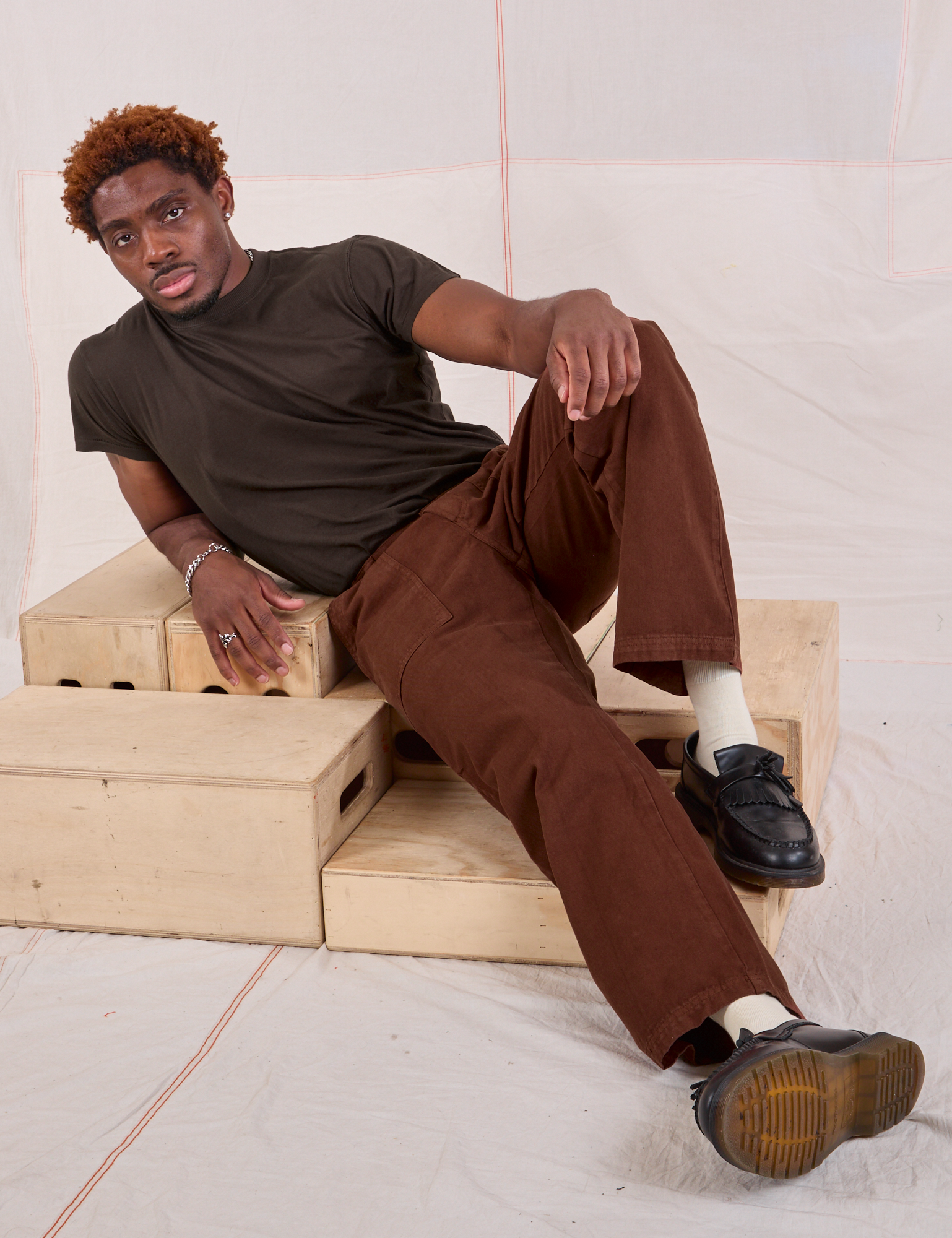 Issac is wearing Mid-Rise Work Pants in Fudgesicle Brown and espresso brown Organic Vintage Tee