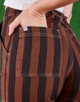 Black Stripe Work Pants in Fudgesicle Brown back pocket close up. Alex has her hand in the pocket.