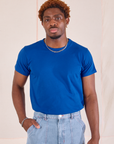 Issac is wearing Organic Vintage Tee in Royal Blue tucked into light wash Carpenter Jeans