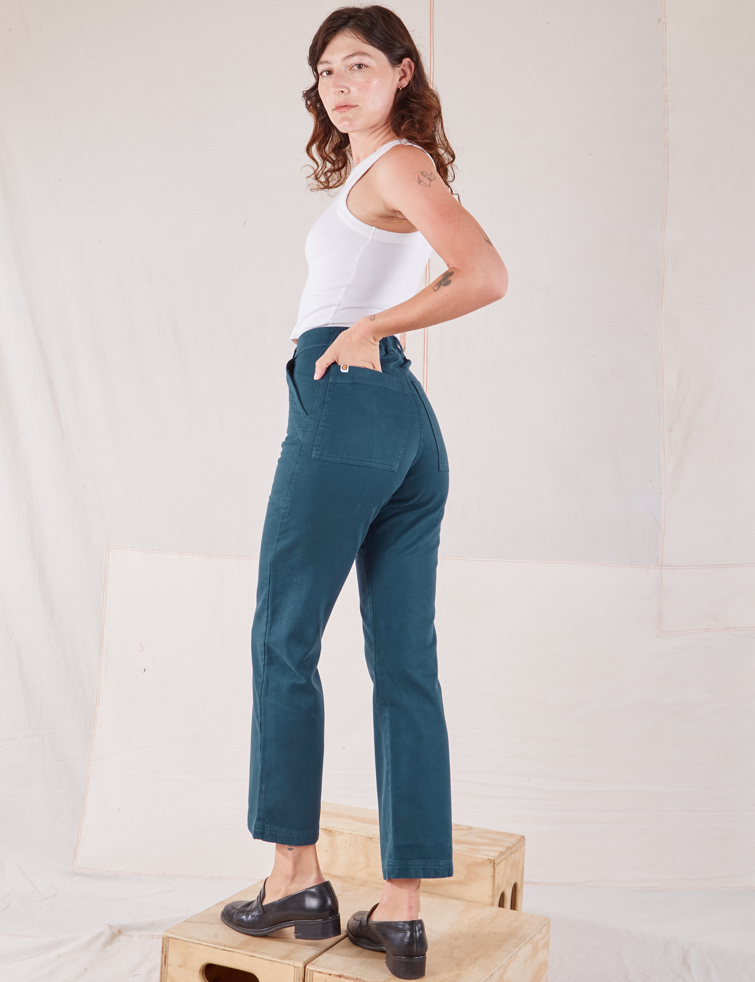 Angled back view of Organic Work Pants in Lagoon on Alex