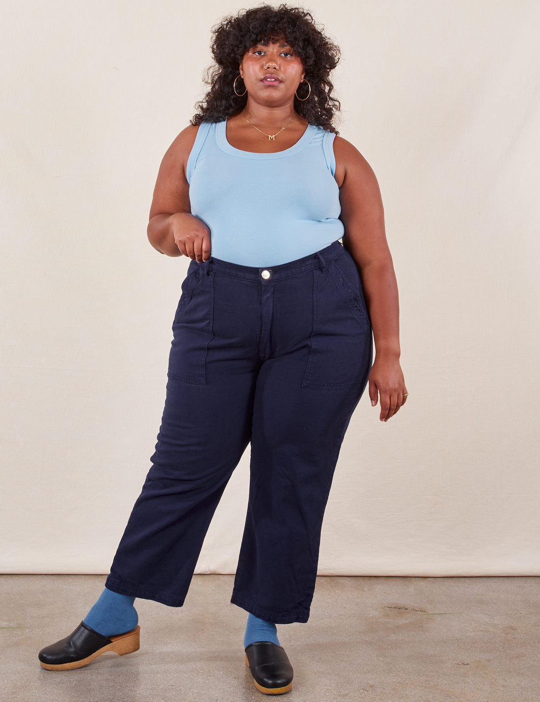 Morgan is 5'5" and wearing Petite 1XL Work Pants in Navy Blue paired with baby blue Tank Top
