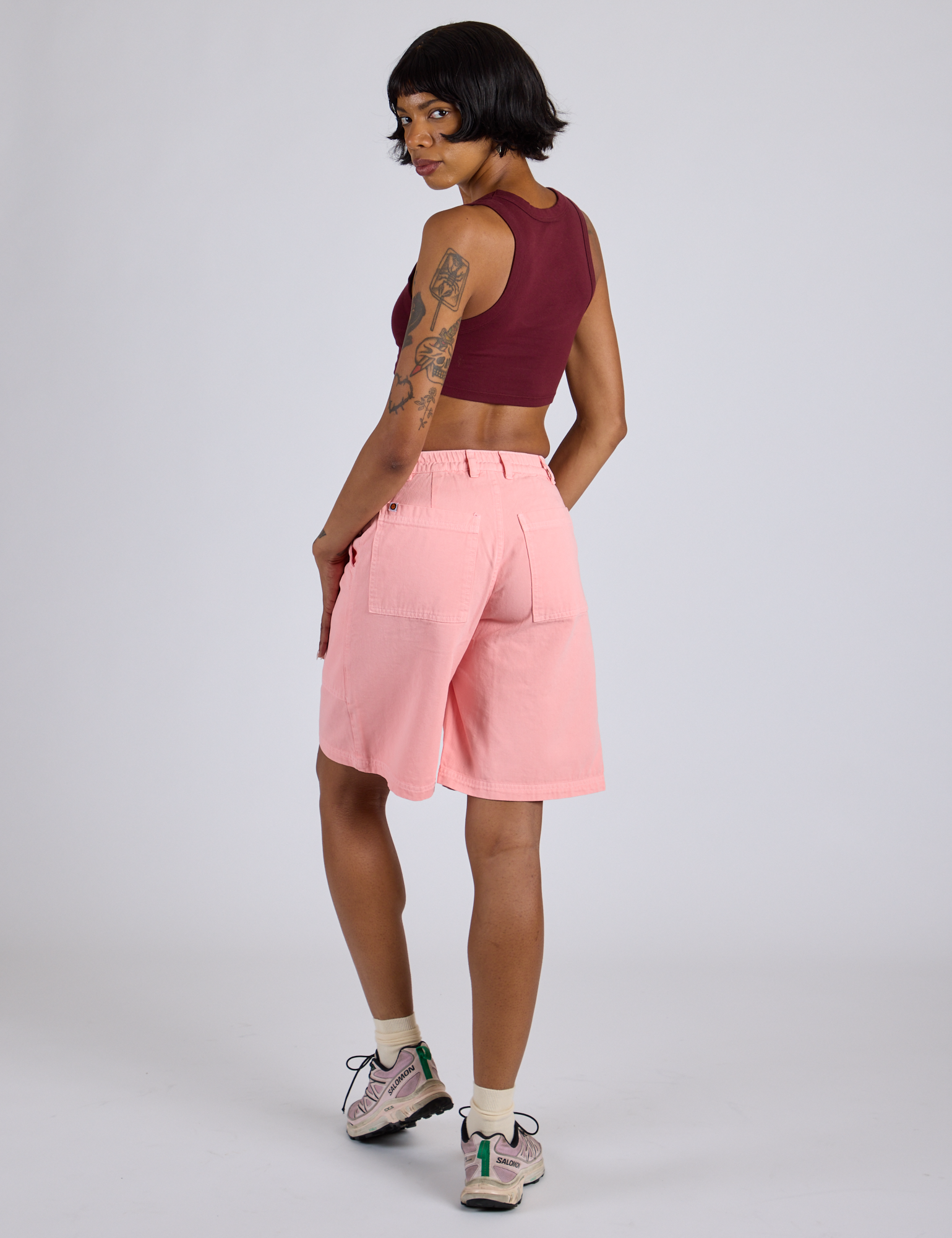 Angled back view of Longline Work Shorts in Baby Pink and red wine Mini Tank