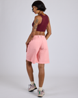 Angled back view of Longline Work Shorts in Baby Pink and red wine Mini Tank