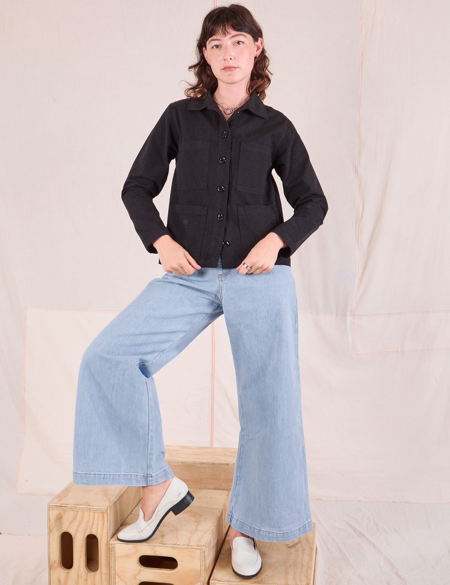 Alex is wearing a buttoned up Ripstop Work Jacket in Basic Black paired with Wide Leg Denim Trouser Jeans in lightwash