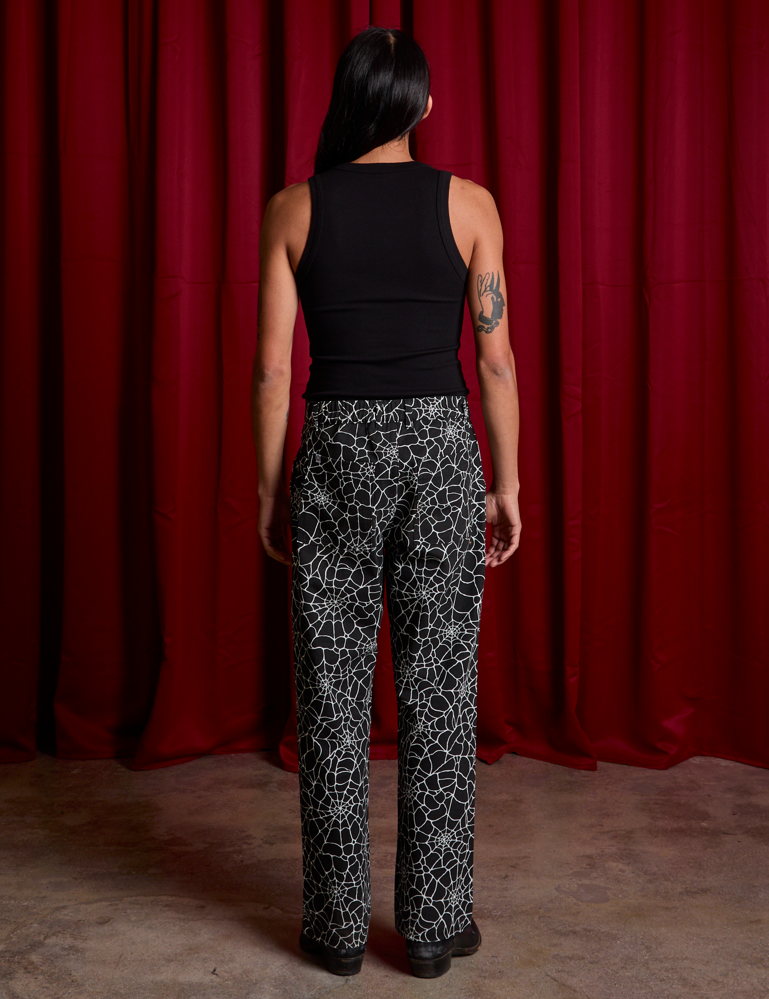 Back view of Work Pants in Spiderwebs and black Cropped Tank on Anthony