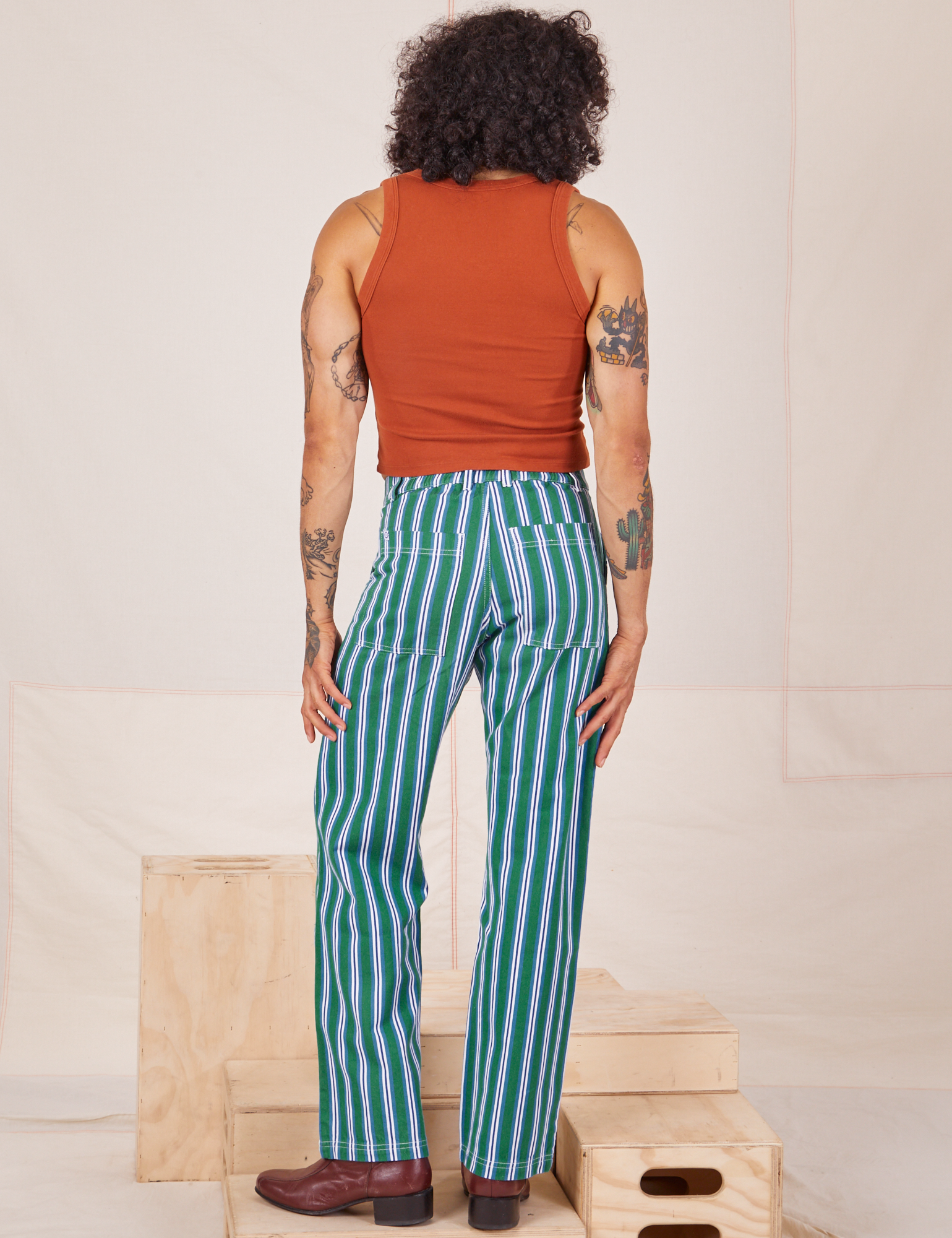 Back view of Stripe Work Pants in Green and burnt terracotta Cropped Tank worn by Jesse