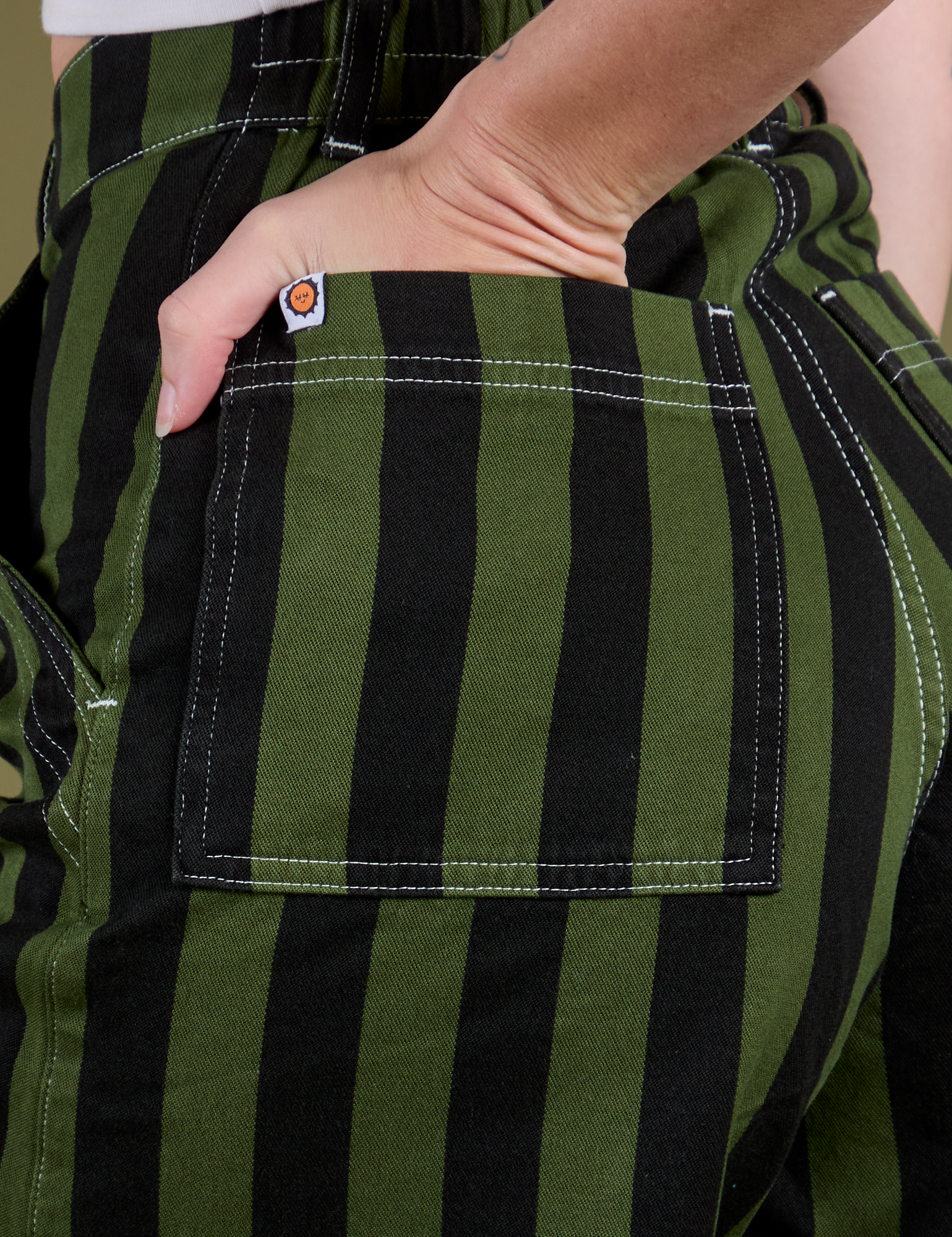 Close up of Alex's hand in the front pocket of Longline Work Shorts in Evergreen
