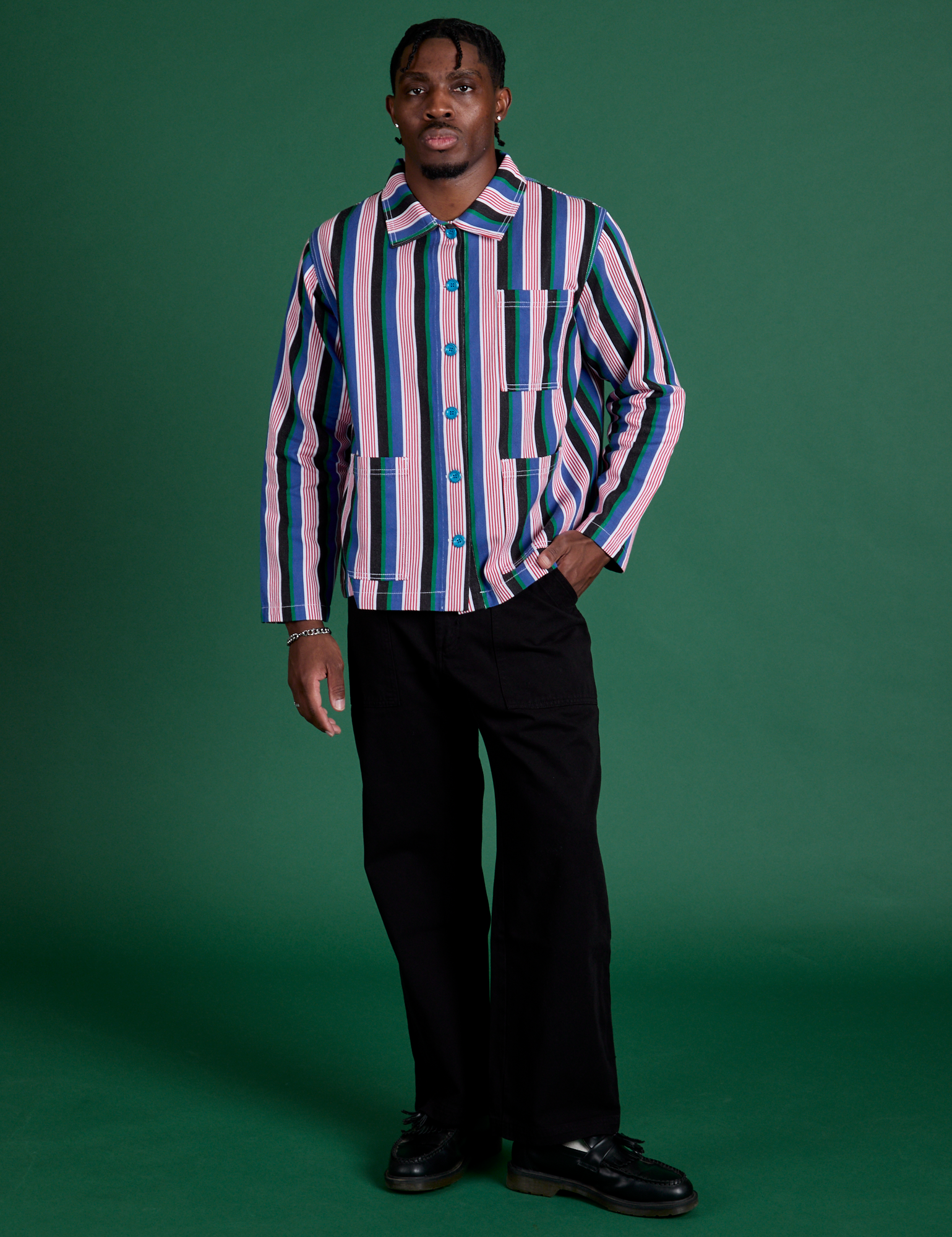 Isaac is wearing a buttoned up Stripe Work Jacket in Pacific Stripe paired with black Work Pants