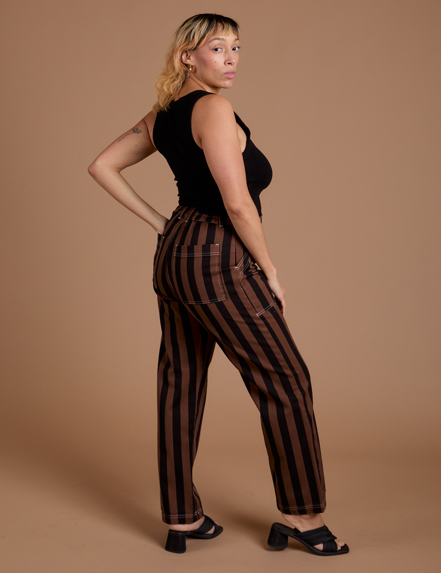 Side view of Black Stripe Work Pants in Fudgesicle Brown and black Cropped Tank on Tiara