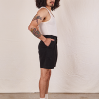 Side view of Trouser Shorts in Basic Black and vintage off-white Tank Top worn by Jesse