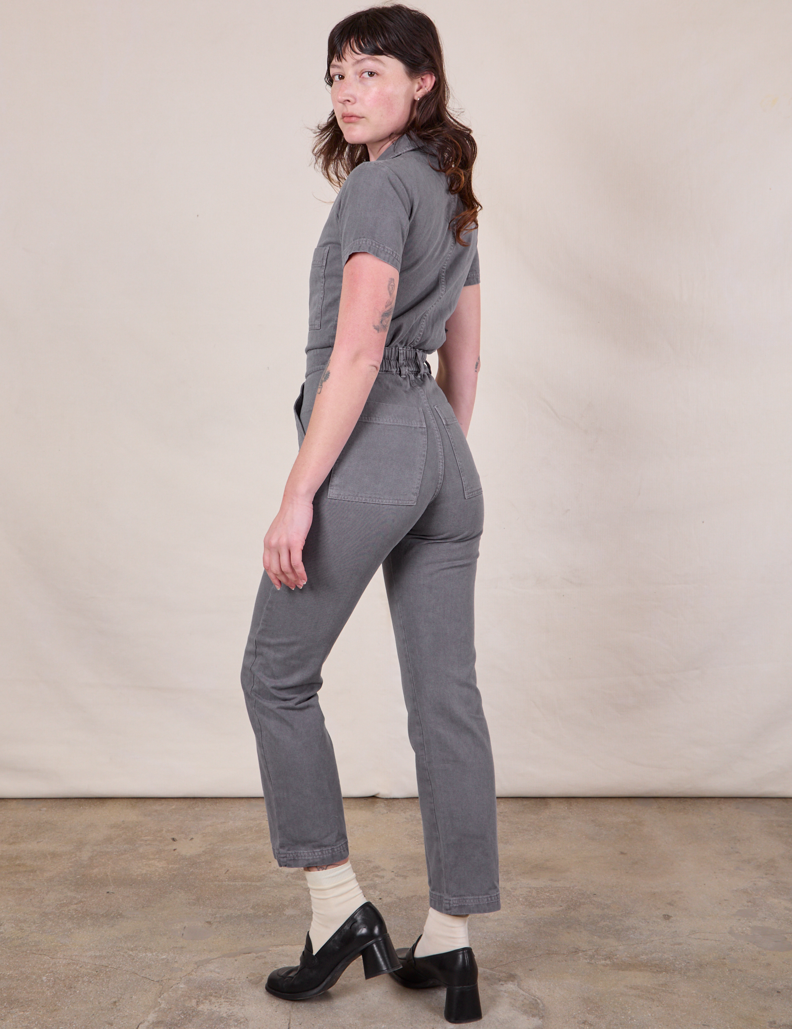 Angled back view of Short Sleeve Jumpsuit in Washed Grey on Alex