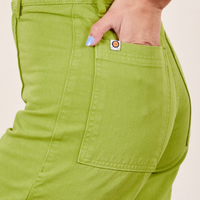 Side view close up of Western Pants in Gross Green. Worn by Soraya with her hand in the pocket.