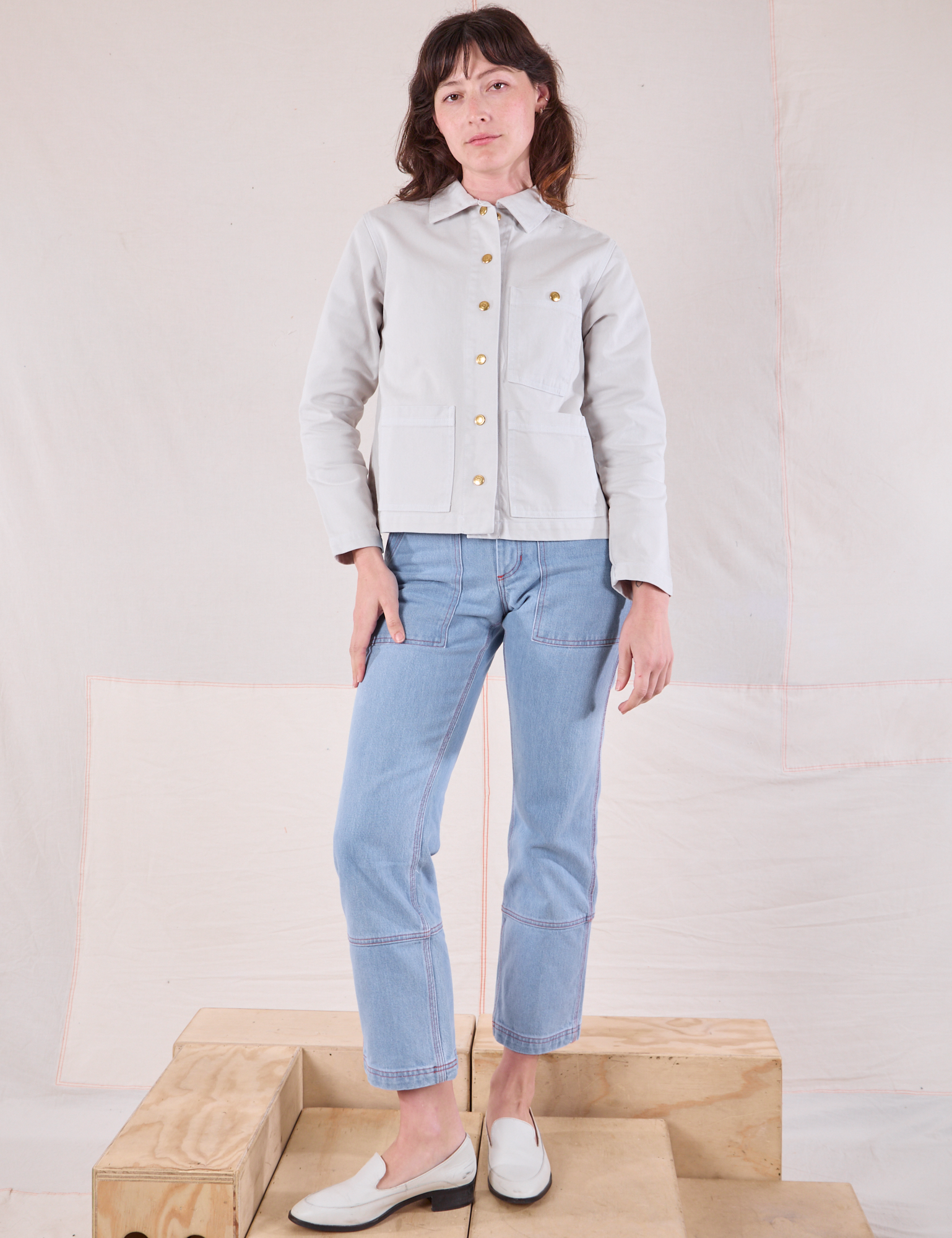 Alex is wearing Denim Work Jacket in Stone White and light wash Carpenter Jeans