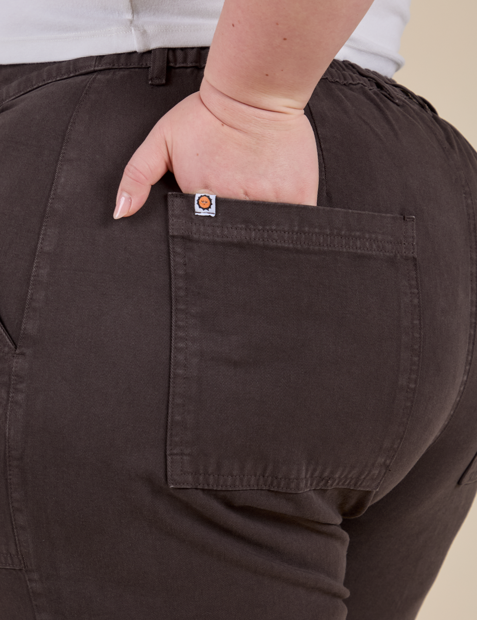 Close up of Ashley's hand in the back pocket of Work Pants in Espresso Brown