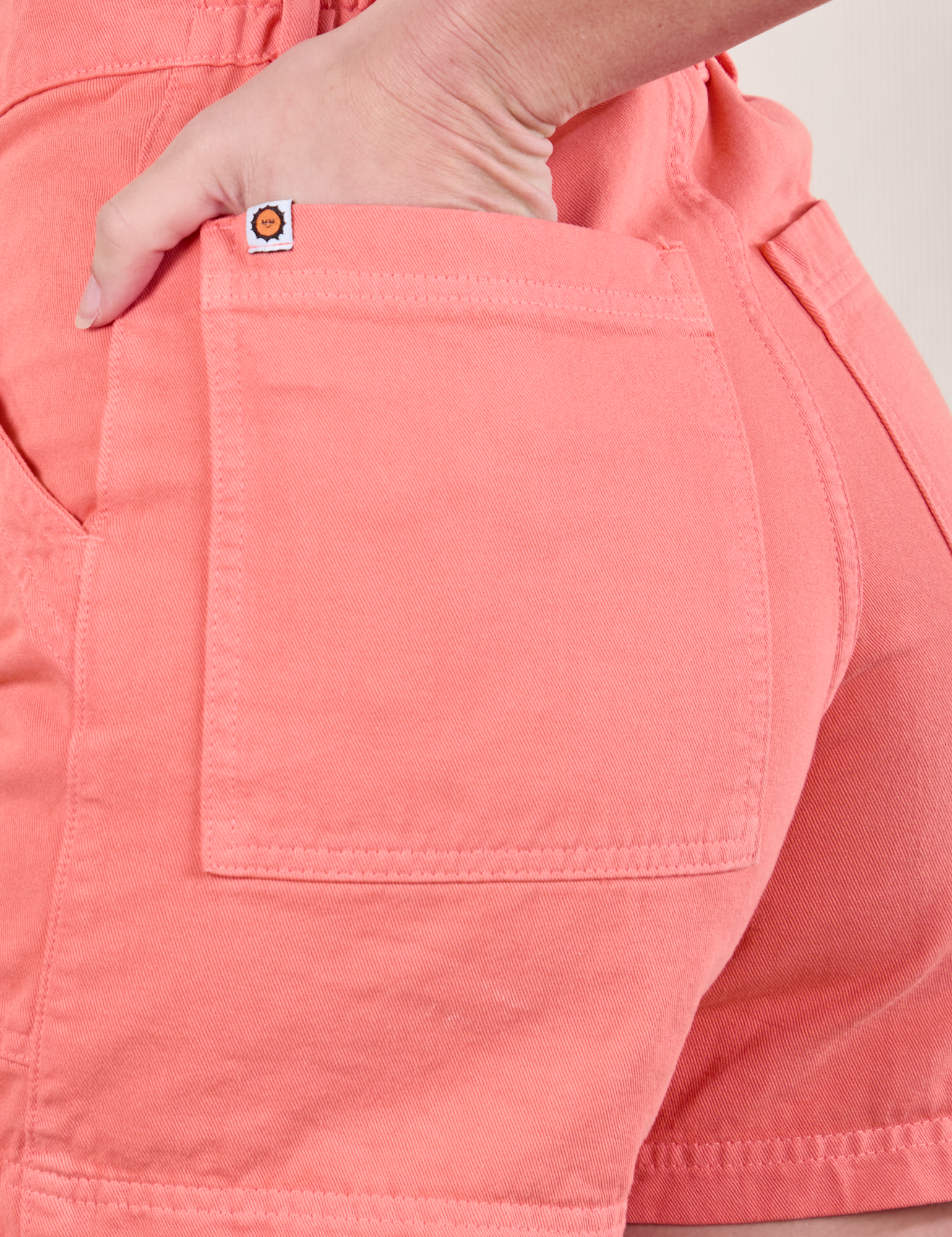 Close up of Alex&#39;s hand in the back pocket of Classic Work Shorts in Flamingo Pink