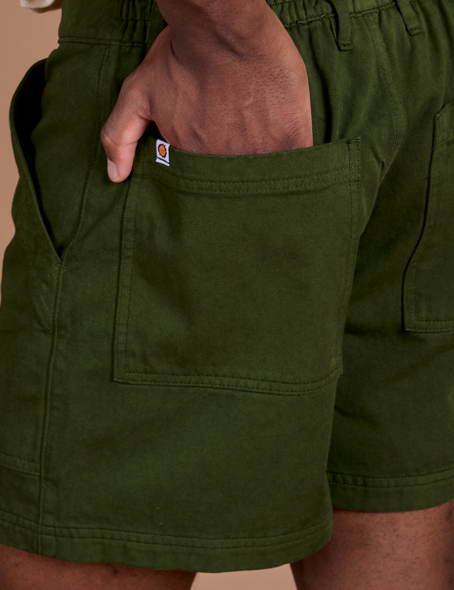 Close up of Isaac's hand in the back pocket of Classic Work Shorts in Evergreen