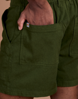 Close up of Isaac's hand in the back pocket of Classic Work Shorts in Evergreen