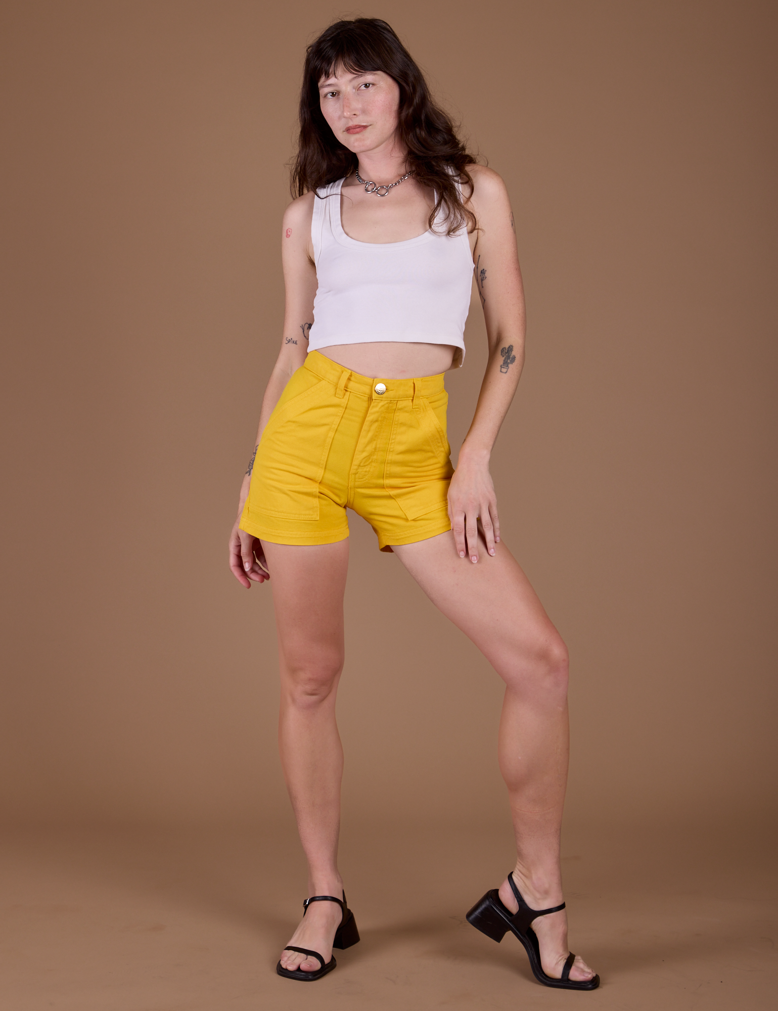 Alex is 5’8” and wearing XXS Classic Work Shorts in Sunshine Yellow paired with a vintage tee white Cropped Tank
