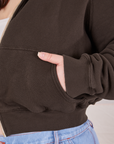 Cropped Zip Hoodie in Espresso Brown front pocket close up. Ashley has her hand in the pocket.