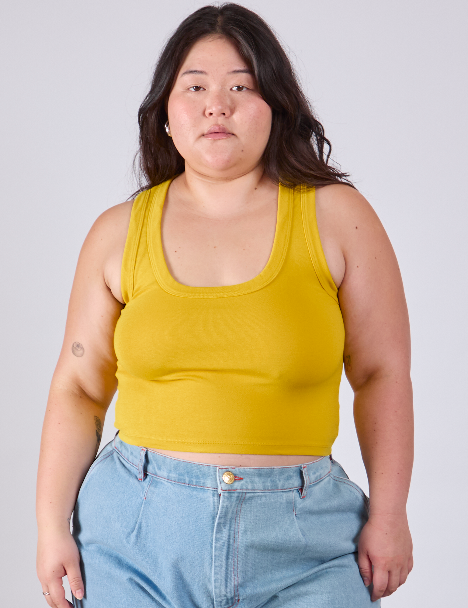 Ashley is 5&#39;7&quot; and wearing L Cropped Tank Top in Golden Yellow