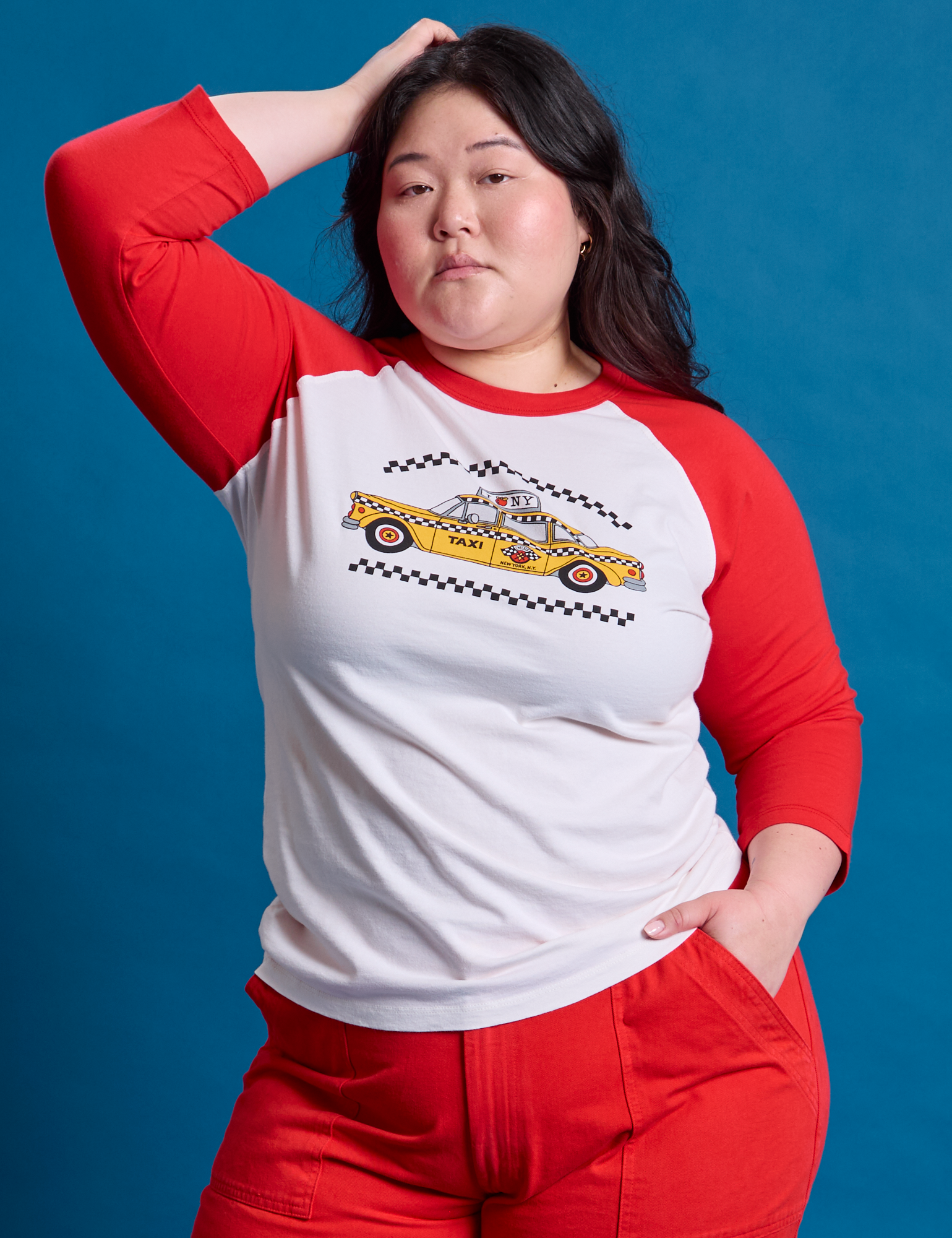 Ashley is 5&#39;7&quot; and wearing L Taxi Raglan Tee in NYC featuring a yellow taxi graphic
