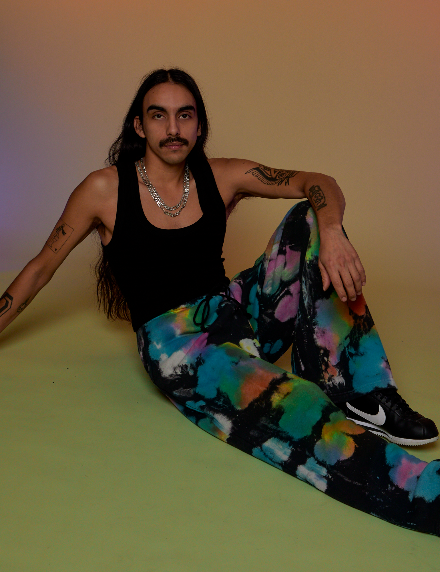 Anthony is wearing Tie Dyed Wide Leg Sweat Pants and black Tank Top