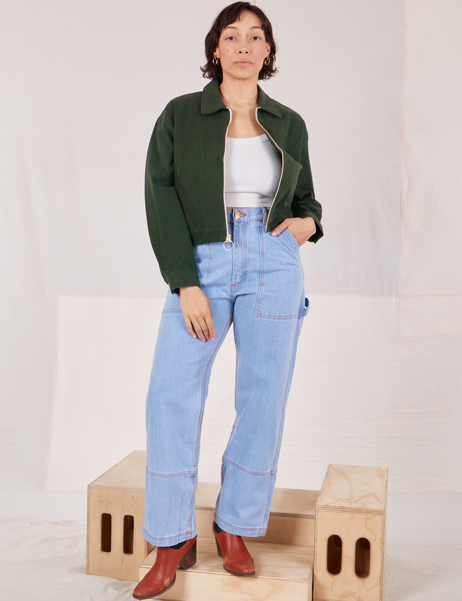 Tiara is wearing Ricky Jacket in Swamp Green with a vintage off-white tee Cami underneath and light wash Carpenter Jeans