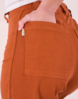 Close up of Soraya's hand in the back pocket of Bell Bottoms in Burnt Terracotta