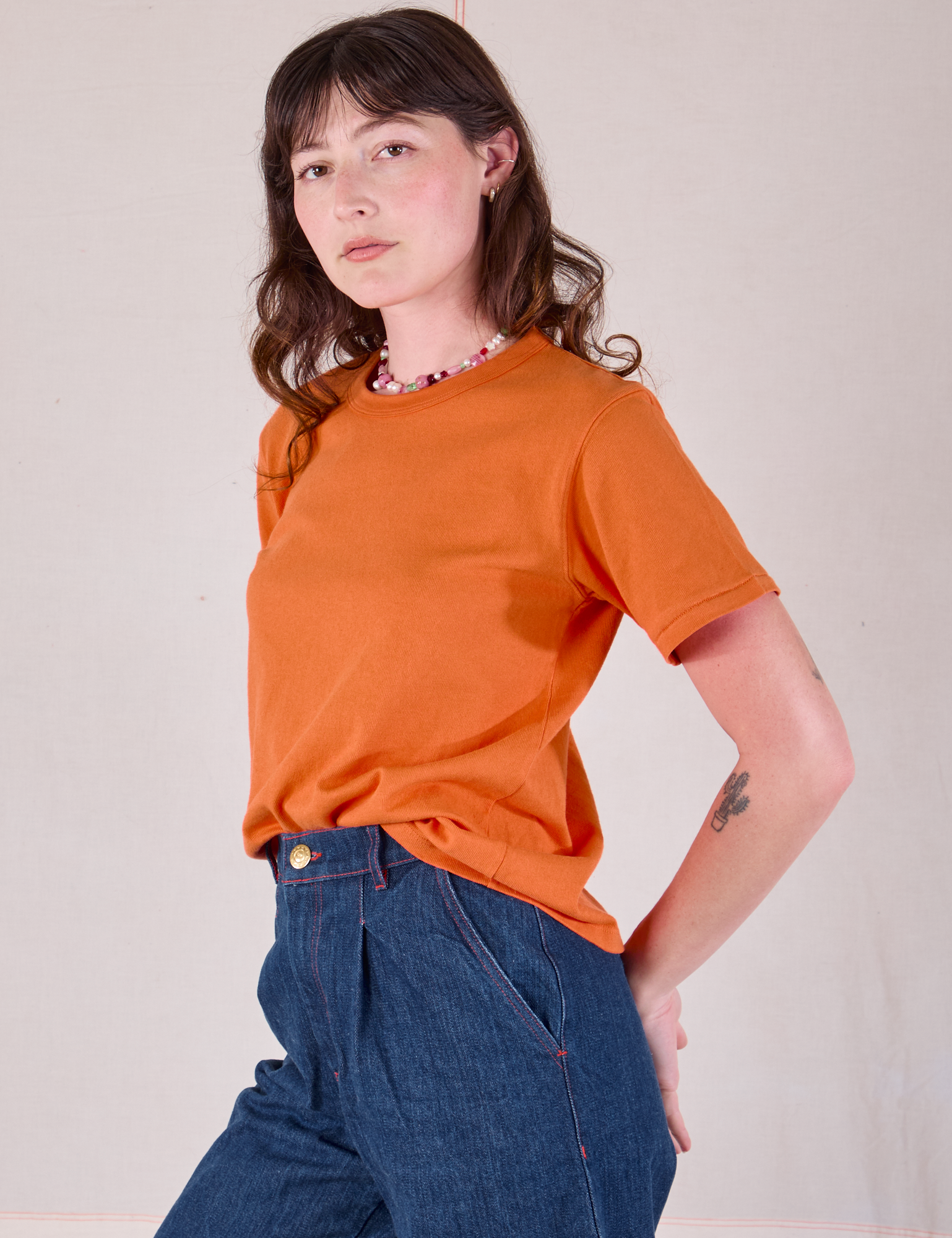 Burly Tee in Construction Orange angled front view on Alex