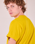 Burly Tee in Golden Yellow angled back view close up on Quinn