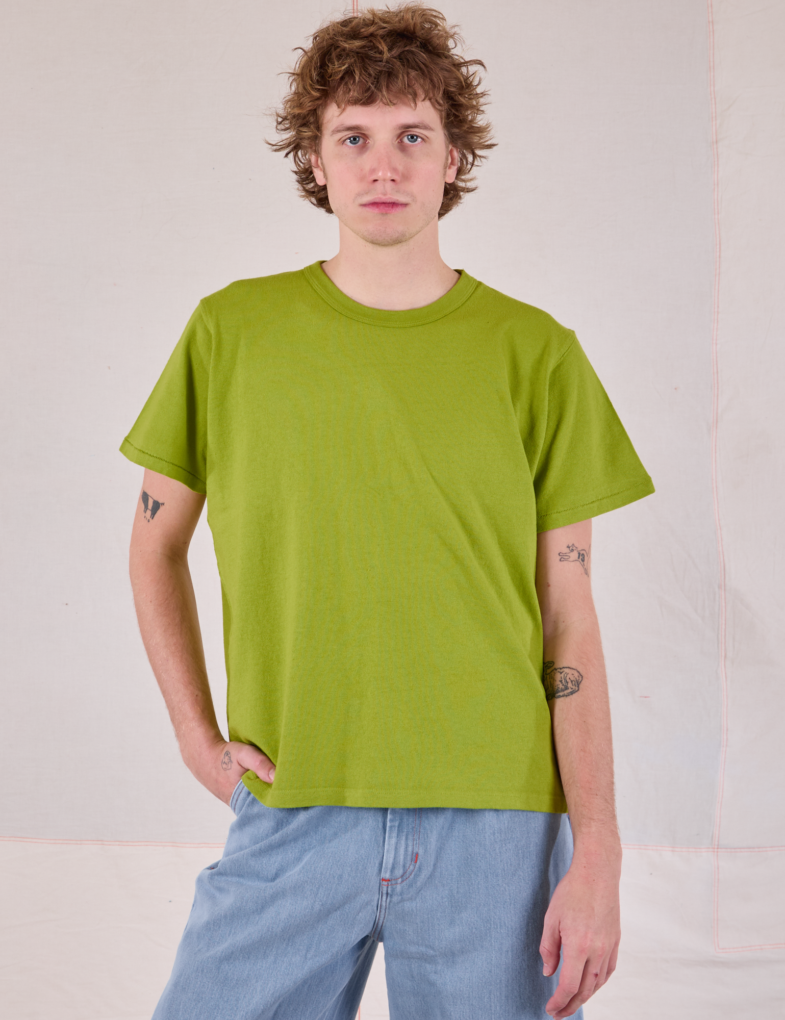 Quinn is 6&#39;3&quot; and wearing S Burly Tee in Gross Green