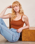 Margaret is wearing Cropped Cami in Burnt Terracotta and light wash Carpenter Jeans