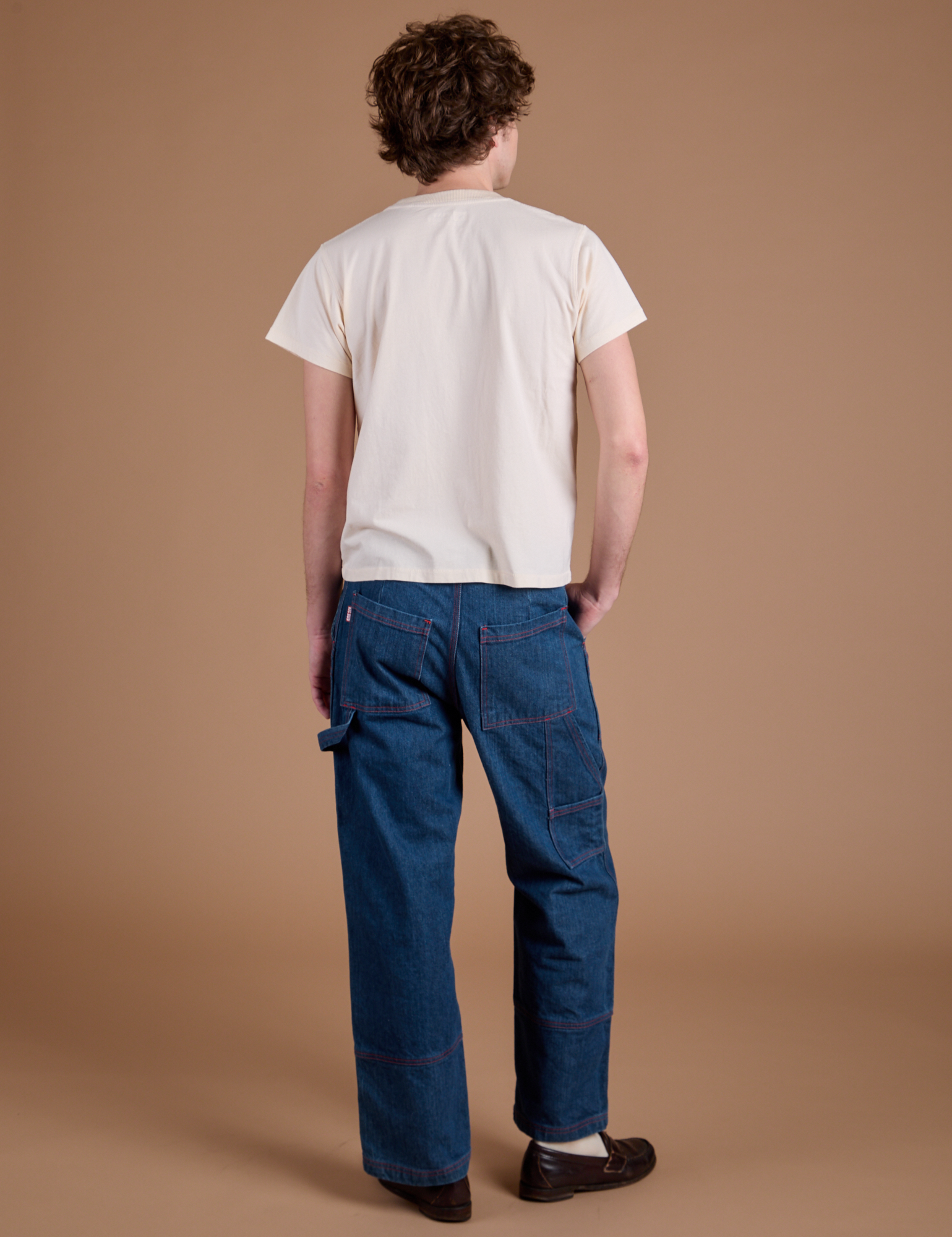 Back view of Carpenter Jeans in Dark Wash and Organic Vintage Tee in Vintage Tee Off-White on Quinn