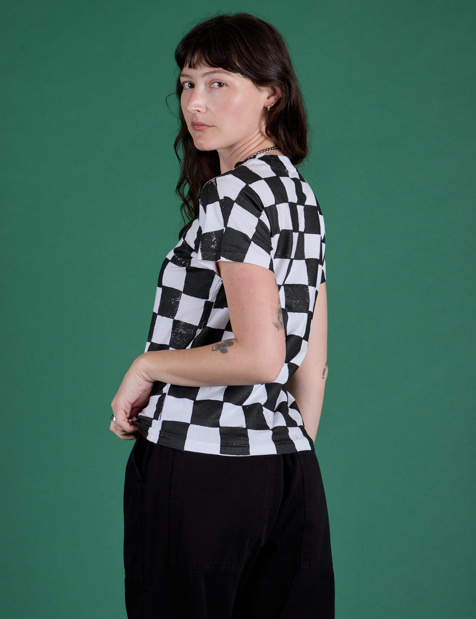 Angled back view of Checker Organic Tee in Black on Alex