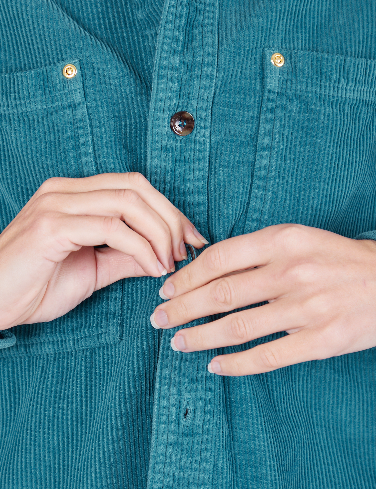 Front close up of Corduroy Overshirt in Marine Blue. Alex is buttoning up the shirt.