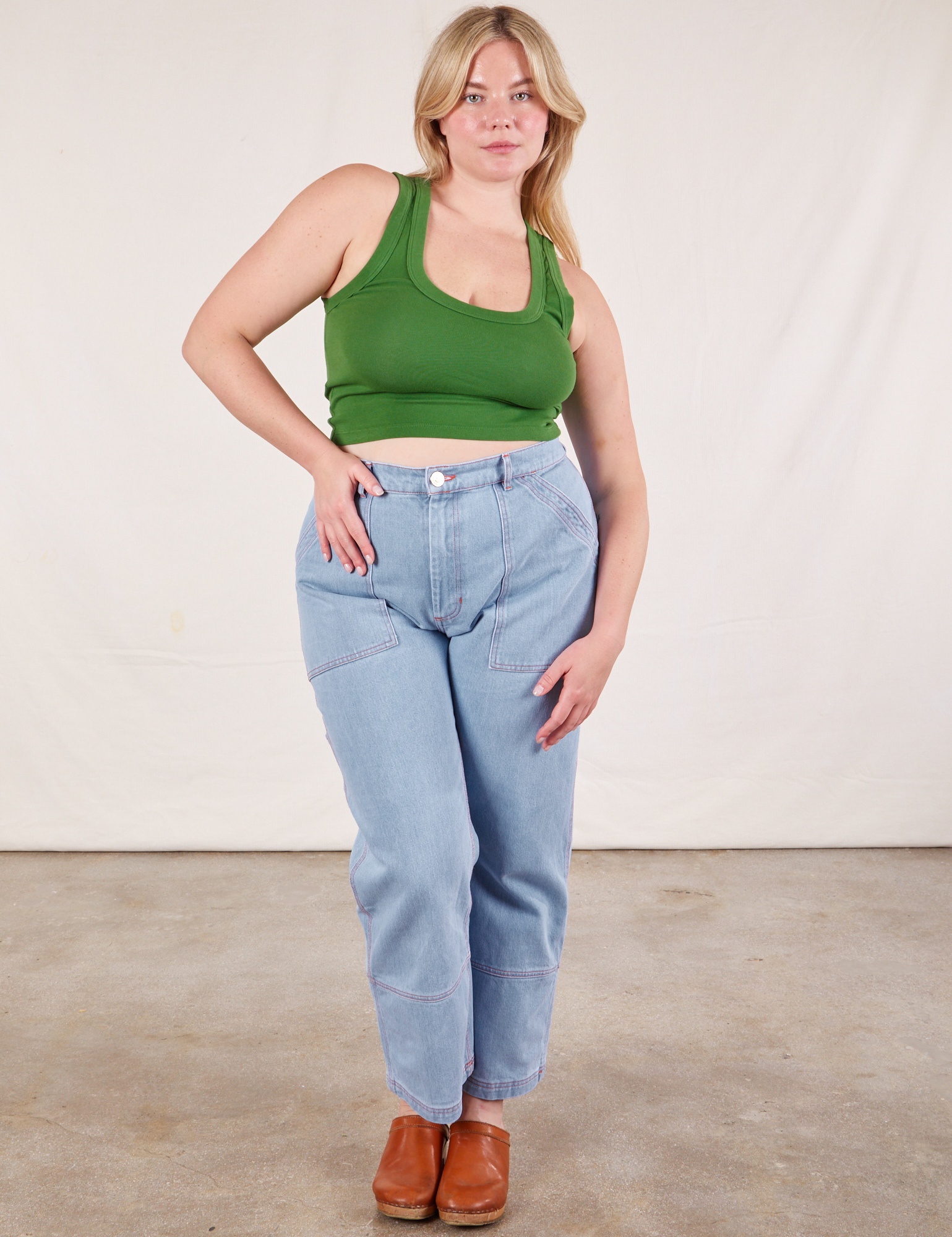 Lish is wearing Cropped Tank Top in Lawn Green and light wash Carpenter Jeans