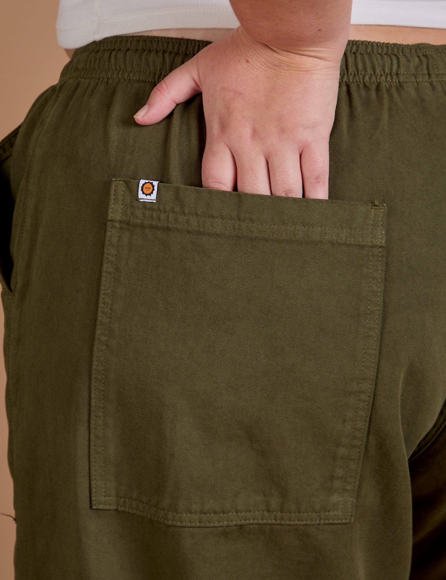 Close up of Juliet&#39;s hand in the back pocket of Drop Pocket Cargo Pants in Surplus Green