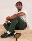 Issac is wearing Easy Pants in Swamp Green and Organic Vintage Tee in Vintage Tee Off-White