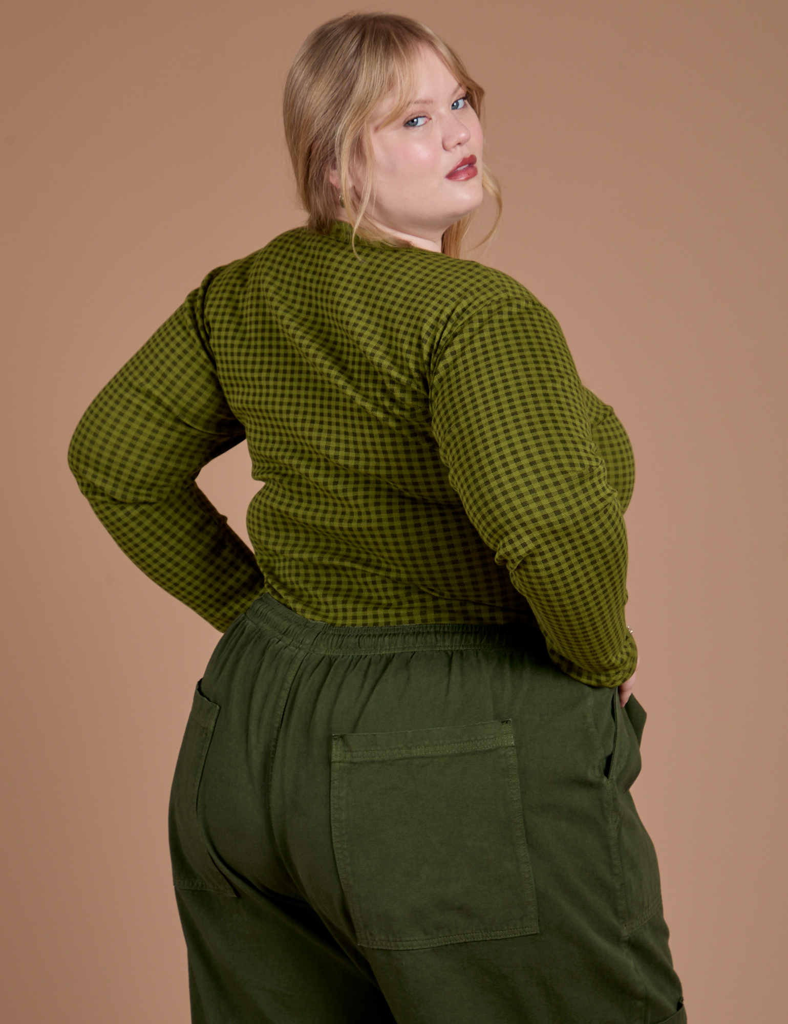 Angled back view of Gingham Long Sleeve Baby Tee in Summer Olive on Juliet