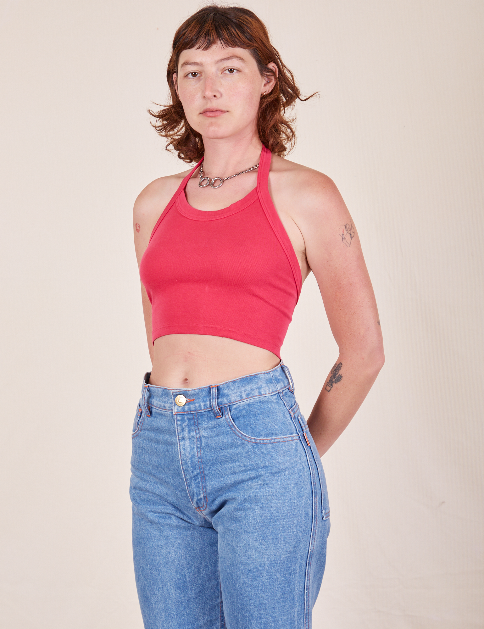Alex is 5&#39;8&quot; and wearing P Halter Top in Hot Pink paired with light wash Frontier Jeans
