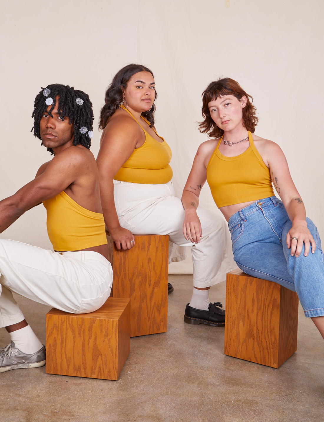Alex, Alicia and Jerrod are sitting on wooden blocks all wearing Halter Top in Mustard Yellow