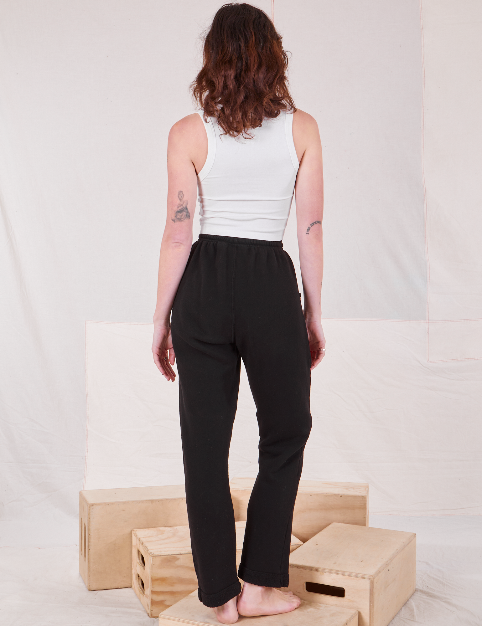 Back view of Rolled Cuff Sweat Pants in Basic Black and vintage off-white Cropped Tank on Alex