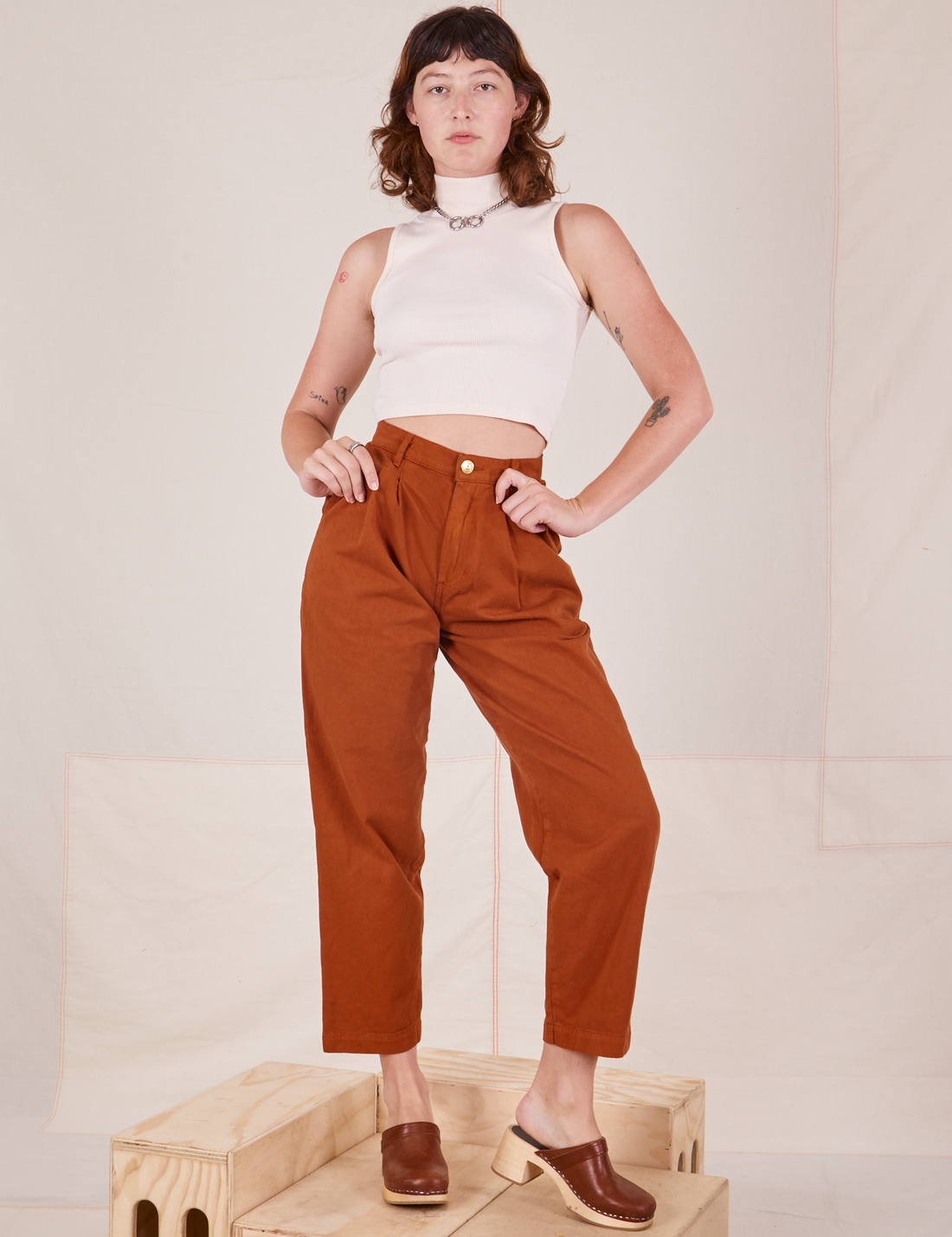 Alex is wearing Heavyweight Trousers in Burnt Terracotta and vintage off-white Sleeveless Turtleneck
