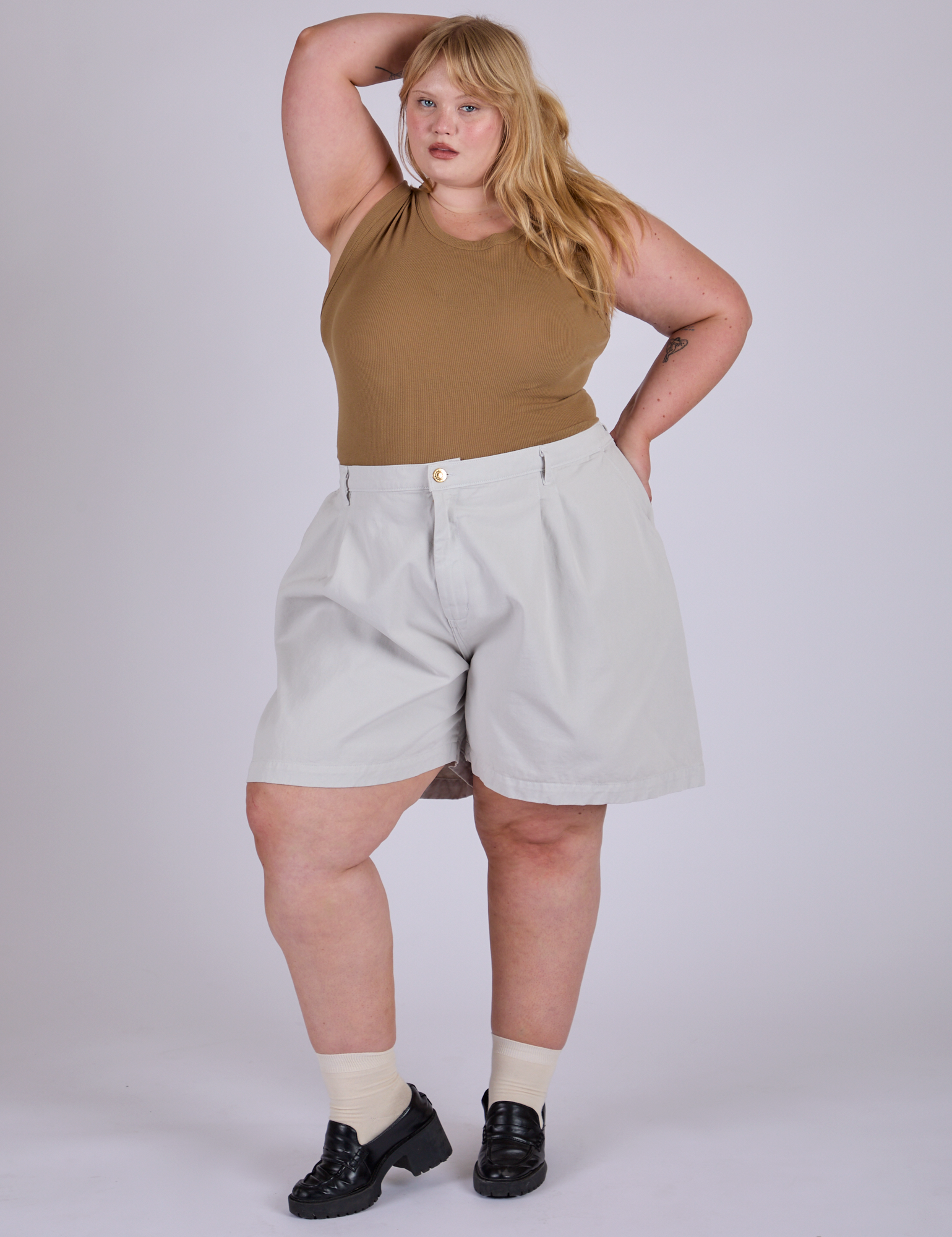 Juliet is 5’7” and wearing 2XL Pleated Trouser Shorts in Dishwater White paired with desert brown Muscle Tee