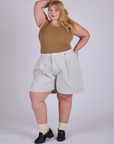 Juliet is 5’7” and wearing 2XL Pleated Trouser Shorts in Dishwater White paired with desert brown Muscle Tee