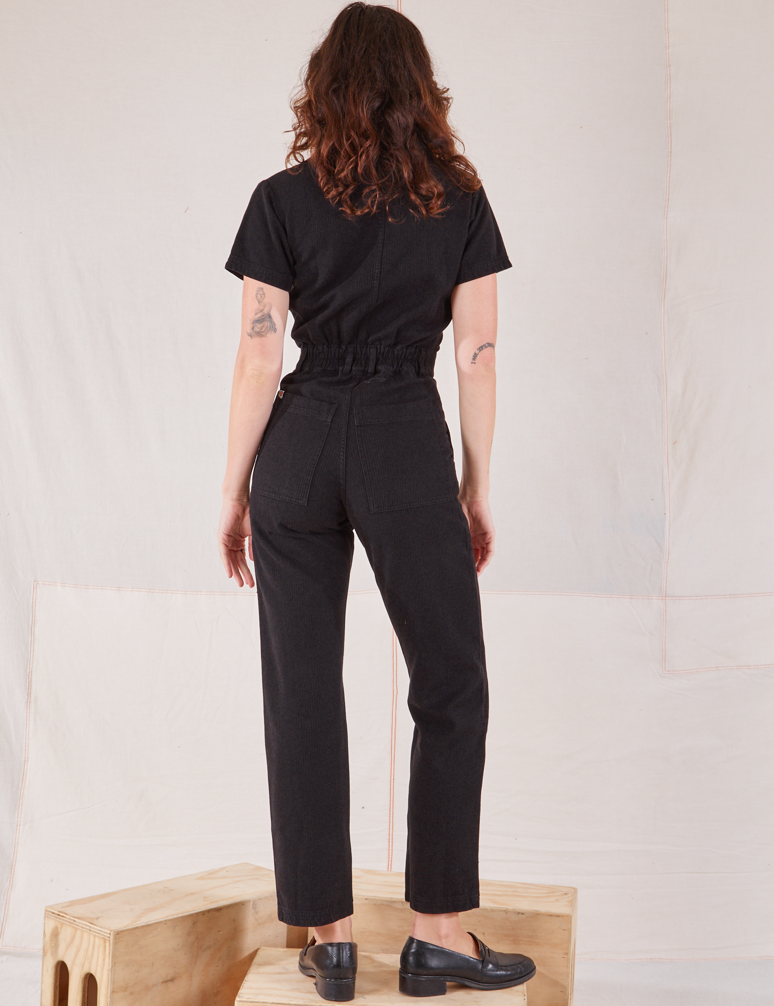 Heritage Short Sleeve Jumpsuit in Basic Black back view on Alex