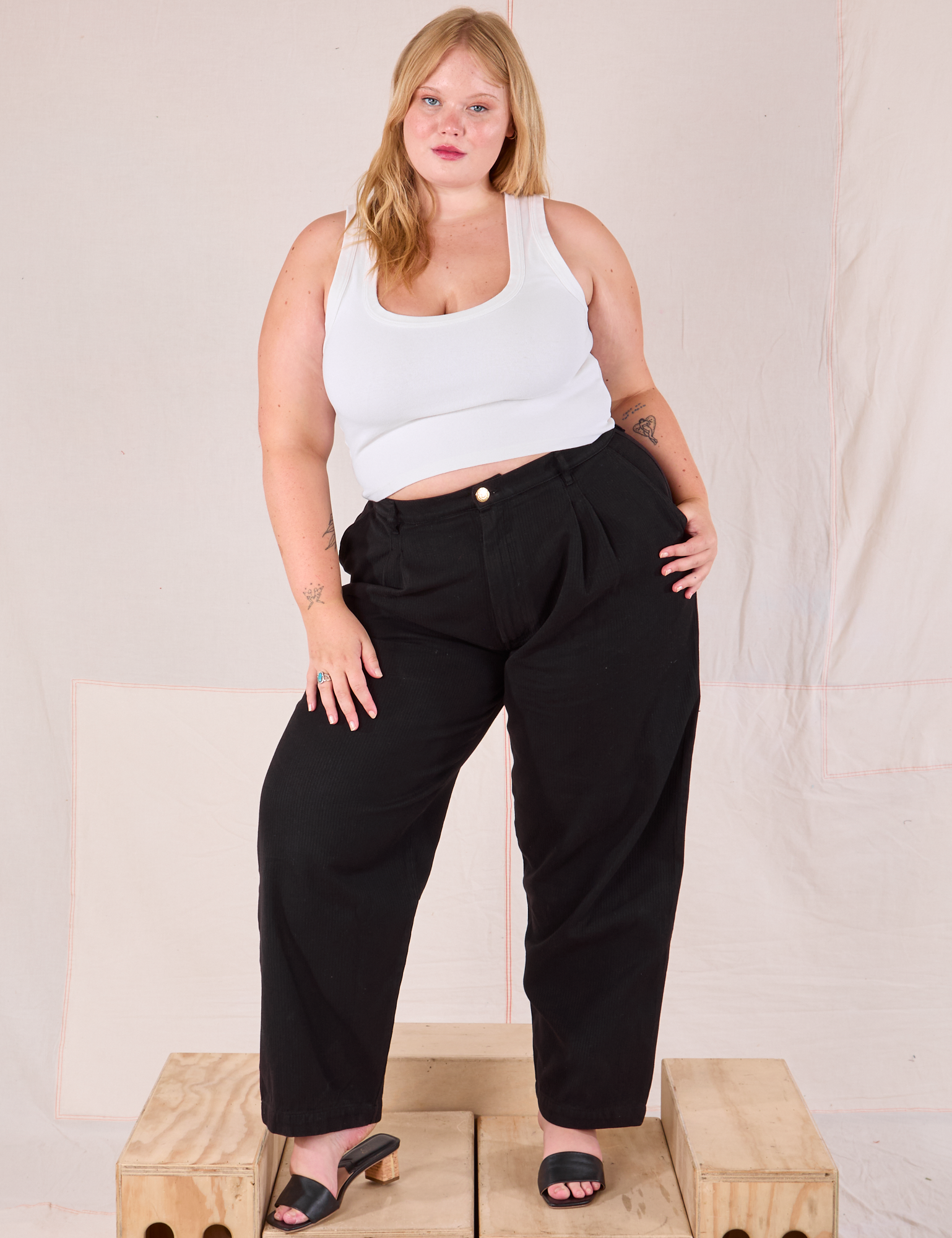 Juliet is 5’7” and wearing 0XL Heritage Trousers in Basic Black paired with a Cropped Tank in vintage tee off-white