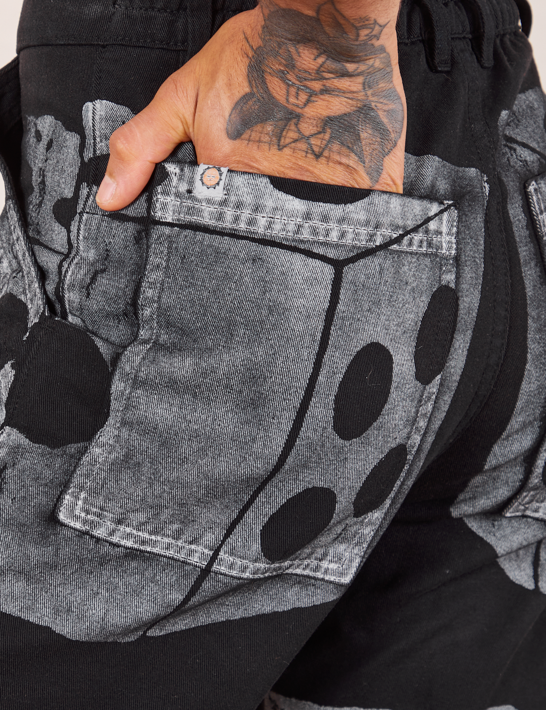 Back pocket close up of Icon Work Pants in Dice. Jesse has their hand in the pocket.