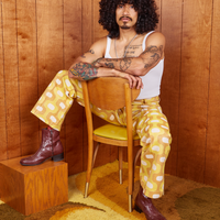 Jesse is sitting in a chair wearing Western Pants in Yellow Jacquard