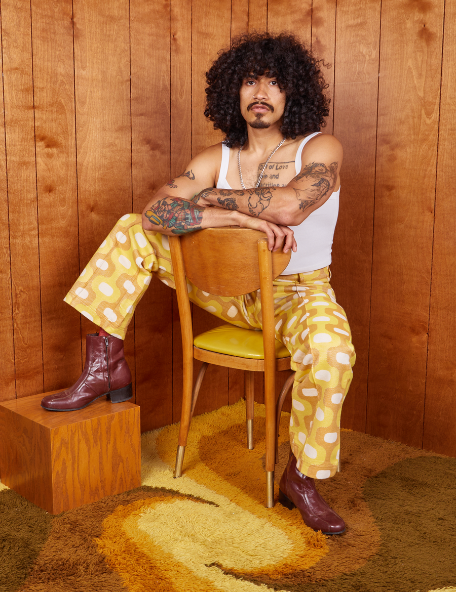 Jesse is sitting in a chair wearing Western Pants in Yellow Jacquard